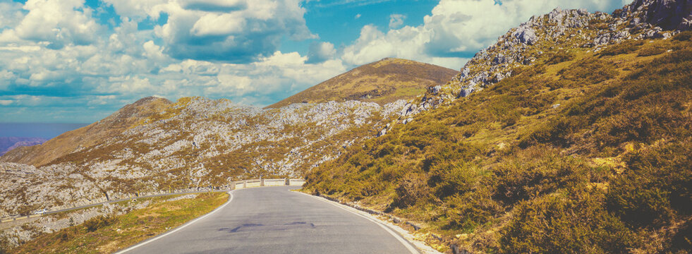 View of beautiful mountain landscape through windscreen on a sunny day. Driving a car on mountain winding road in National park Picos de Europa. Cantabria, Spain, Europe