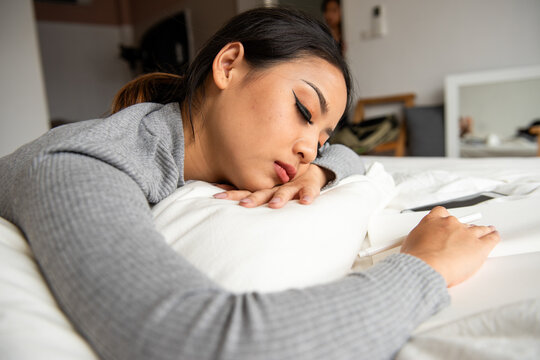 Woman resting on bed peacefully.