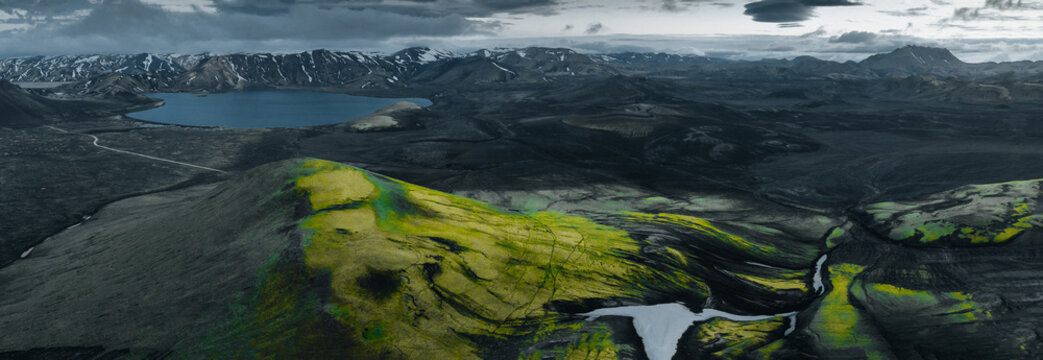 Panoramic view of Lj&oacute;tipollur crater lake in Iceland's Highlands, surrounded by dark volcanic slopes beneath dramatic storm clouds. A remote and breathtaking volcanic landscape.