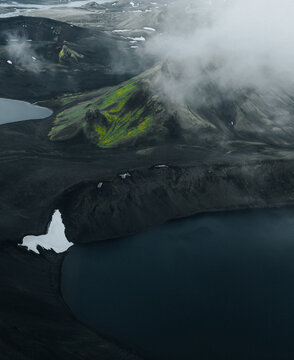 Panoramic view of Lj&oacute;tipollur crater lake in Iceland's Highlands, surrounded by dark volcanic slopes beneath dramatic storm clouds. A remote and breathtaking volcanic landscape.