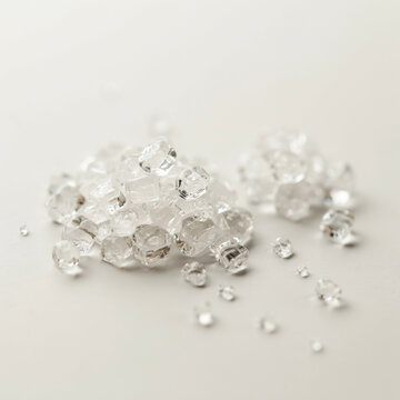 Pile of sparkling clear diamonds and raw gemstones on white background
