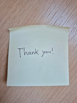 Handwritten thank you message on yellow sticky note