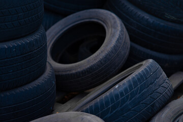 Stack of old used car tires in recycling yard. © TetianaRUD