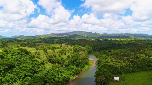 Summer landscape of a long winding river in a nature reserve. The riverbanks are lush with vegetation. Aerial view of mountain river landscape. Dominican Republic National Park.