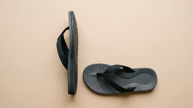 Blank black flip flop sandals on neutral background for footwear branding mockup