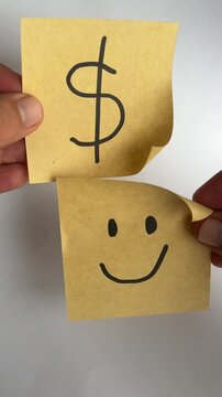 Hand holding dollar sign and smiley face notes positive money mindset