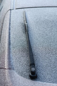 Close up back view red car covered with heavy ice and frost in winter. Selective focus.