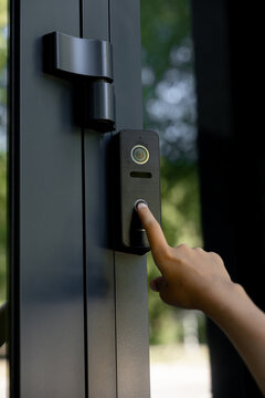 Person pressing the button on a modern smart video doorbell intercom system