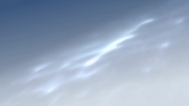 Soft sunlight shines through pale blue clouds across an open daytime sky