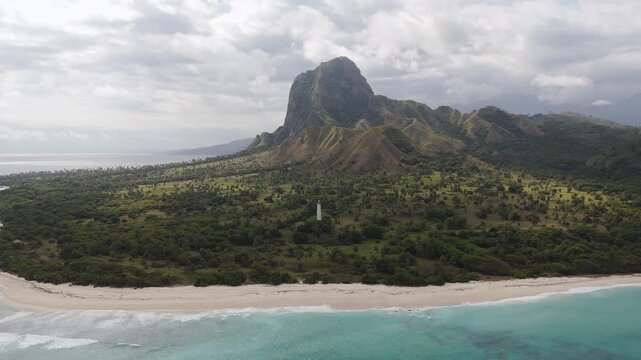 Aerial view of Nuca Molas peak rising above lush green hills and tropical vegetation in Satar Mese Barat, East Nusa Tenggara, Indonesia.