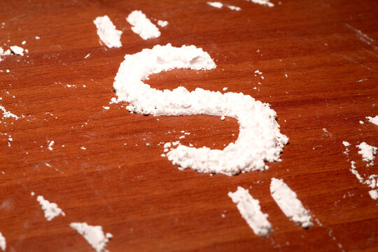 Drug trafficking featuring a dollar sign formed from cocaine