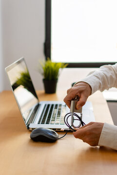 Vertical close up of hands securing mouse cable with metal padlock