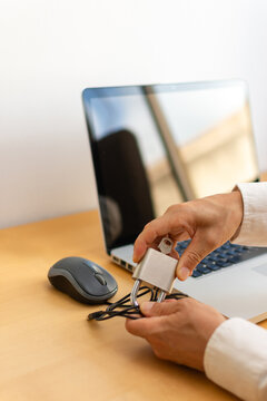 Vertical rear view of hands securing mouse cable with padlock