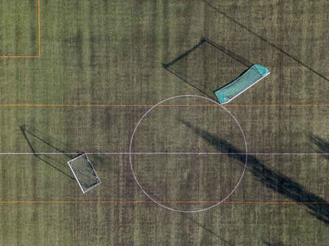Aerial view of Virpiniemi Sport soccer field with goalposts, white pitch markings, and long shadows cast on the green grass Oulu, North Ostrobothnia, Finland.