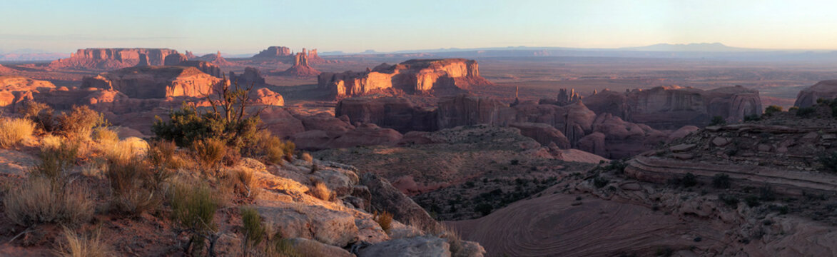 Beautiful wide panoramic view of giant sandstone canyon rock formations in desert at sunrise