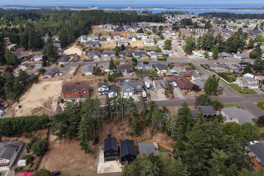 Aerial view of the residential neighborhood at Airport Heights with houses, streets, and surrounding evergreen trees in North Bend, Oregon, United States.