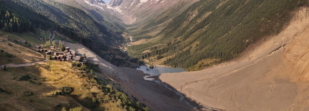 Aerial view of the aftermath of a massive rock and ice avalanche covering the valley floor, with debris and a newly formed lake near the village of Blatten, Wallis, Switzerland.
