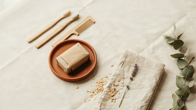 Bamboo toothbrushes and soap bar on a linen cloth with dried lavender with sustainable personal care items with arranged neutral linen, fabric natural accents