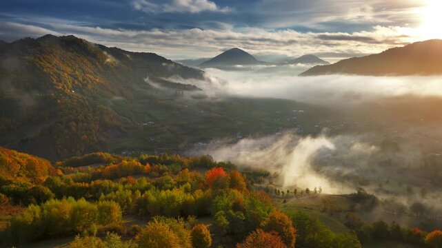 Misty autumn mountain landscape at sunrise, aerial landscape, drone flying through the clouds