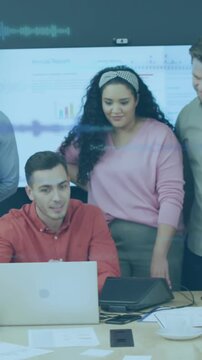 A group of diverse businesspeople discuss work during a meeting at a modern office