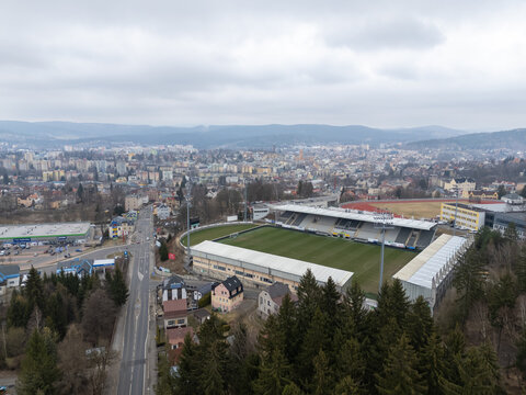 Jablonec nad Nisou, Czech Republic - March 23, 2025: Aerial view of Stadion Strelnice, home of FK Jablonec, surrounded by the city and wooded hills.