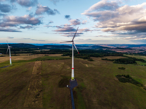 Aerial view of wind turbines at Lezky in the countryside with rolling hills and a cloudy sky in Lubenec, Usti nad Labem Region, Czechia.