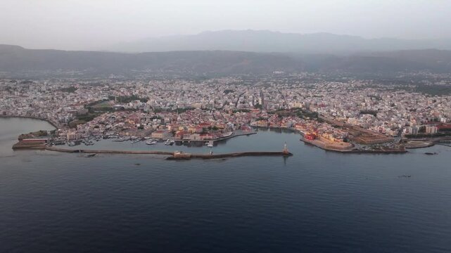  View of Chania with the amazing lighthouse, mosque, venetian shipyards, Crete, Greece.Waves crashing on lighthouse, Beautiful Greece and best scenic places - panorama