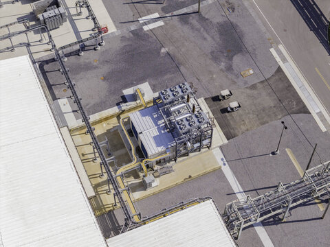 Aerial view of a natural gas generator power module at an industrial facility with piping, asphalt surfaces, and two utility vehicles in Clarksville, Tennessee, United States.