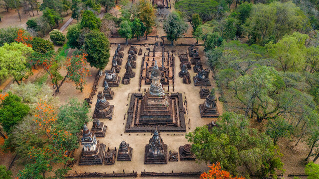 Aerial view of the ancient stone stupas and temple ruins of Si Satchanalai Historical Park surrounded by lush forest, Si Satchanalai, Sukhothai, Thailand.
