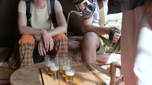 Marrakech, morocco. August 9, 2026. Authentic moroccan hospitality ritual featuring a person pouring hot mint tea from a traditional silver teapot into small glasses on a wooden tray