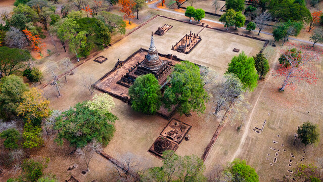 Aerial view of Si Satchanalai Historical Park featuring an ancient chedi surrounded by historic ruins and lush trees in Si Satchanalai, Sukhothai, Thailand.