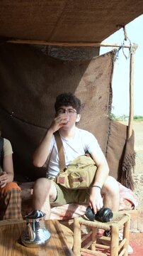 Marrakech, morocco. August 9, 2026. Young man relaxing and sipping authentic mint tea from a glass in a traditional berber tent during a trip to marrakech, morocco