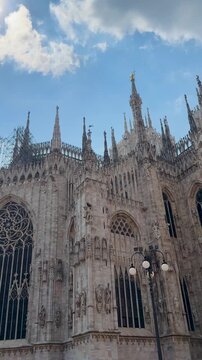 Gothic facade of Milan Duomo beneath blue sky