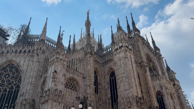 Gothic spires of Milan Duomo cathedral under blue sky