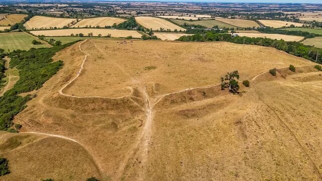An aerial receding rising view from the remains of the Iron Age Hillfort in rural Leicestershire, UK in late summertime