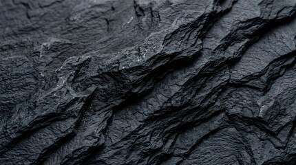 Fototapeta premium Closeup of dark grey slate stone texture with sharp jagged edges and natural geological layers creating a rugged abstract pattern