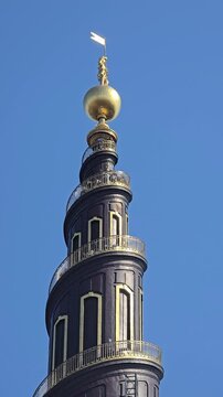 Copenhage, Denmark. August 14, 2026, Famous baroque Church of Our Saviour tower with its golden spire, external winding staircase, and orb, a popular landmark in Copenhagen