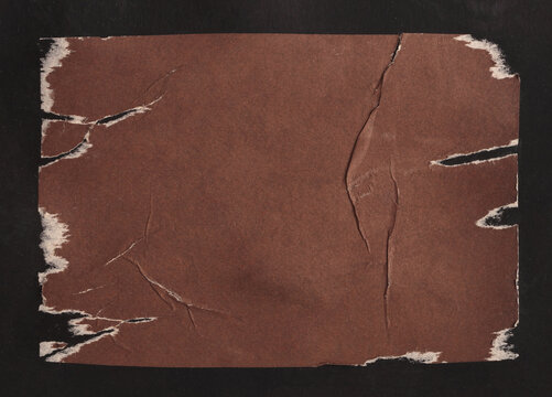 Brown Crumble ragged wrinkled paper pieces patch collage. Art Poster wall. Abstract grunge dirty texture black background.