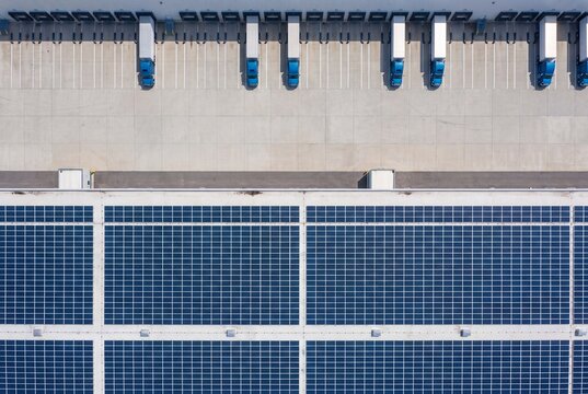 Warehouse distribution center with solar panels and trucks at loading docks