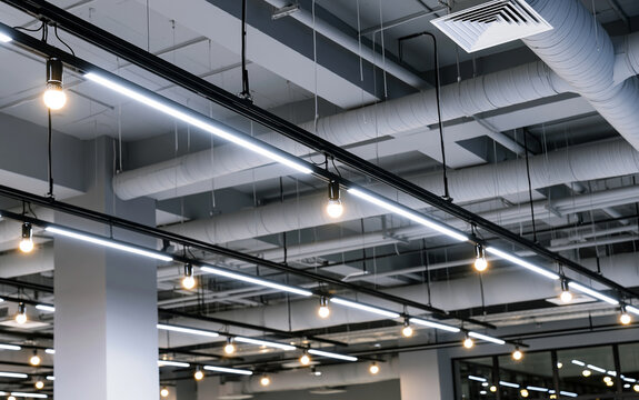 Directional LED lights on rails under the ceiling in a modern warehouse, shopping center building, office or other commercial real estate object.