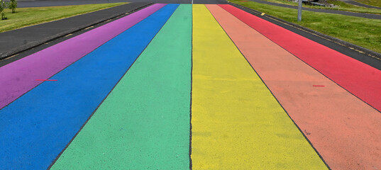 A close-up texture of a colorful rainbow road surface found along the roads of Iceland, featuring vibrant patterns and unique details shaped by the natural landscape. © Asanee