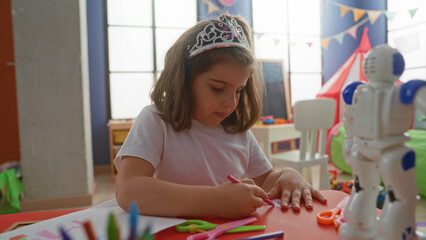Girl folding paper with hands and scissors while drawing at table in building  playful concentration creativity focus. © Krakenimages.com