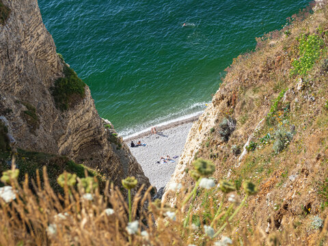 Vista cenital de la playa de arena blanca sobre mar turquesa desde los acantilados de Etretat, viajando por la costa de Normand&iacute;a en Francia, verano 2022