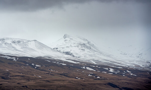 Snow covered mountains in icelandic winter landscape. Storm clouds winter