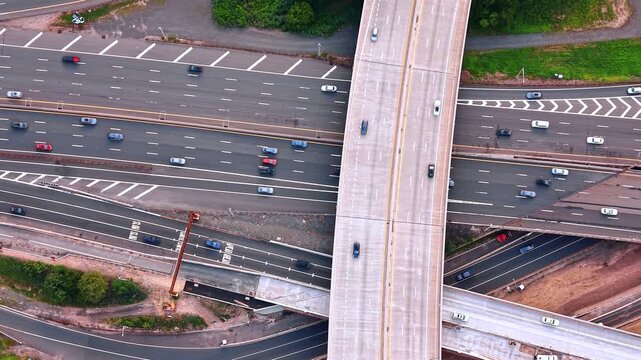 Descending over the trestle above the multi-lane highways at daytime. Hectic traffic on the roads.