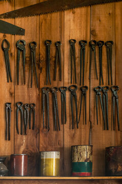 Pliers, Saws and Cans on Wooden Wall