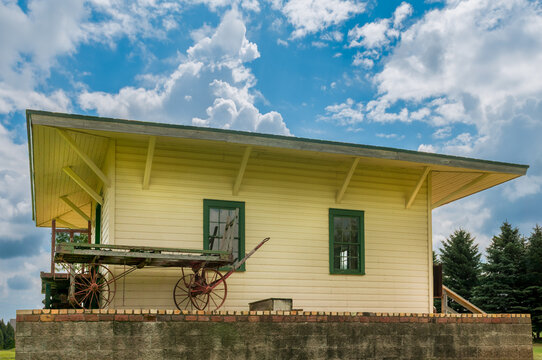 Yellow Train Station With Luggage Cart Parked Outside