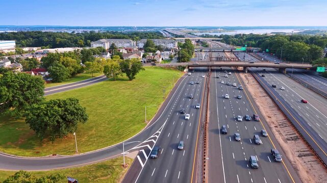 Flight over the multi-lane highways along the green roadsides. Lively Garden State Parkway in Middlesex County, New Jersey.