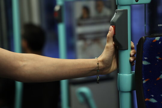 Main de passag&egrave;re appuyant sur le bouton d&rsquo;arr&ecirc;t d&rsquo;un autobus