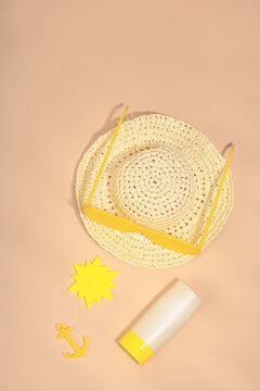 Travel concept flat lay with a light blue miniature suitcase, a straw hat, summer accessories